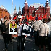 Огромное количество людей несет портреты своих род
