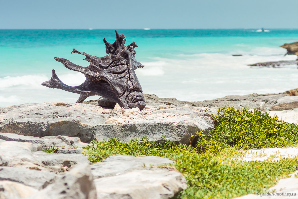 Тулум, черная голова из дерева на берегу Тулум, черная голова из дерева на берегу
